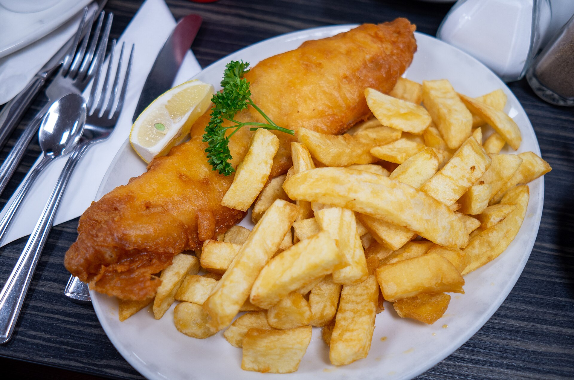 A plate of battered fish and chips with a lemon wedge (stand-in photograph, Blackpool)